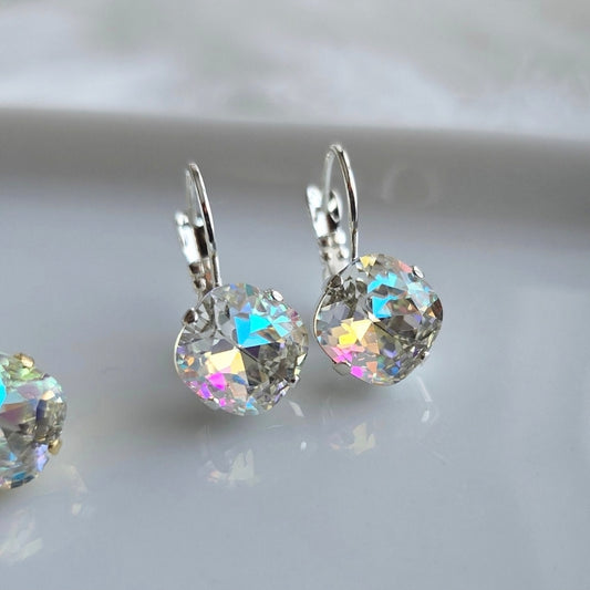 Pair of Wixies Iridescent 10mm Cushion Lever Back earrings with sparkling rainbow facets on a smooth white surface