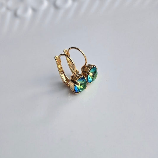 Wixies *Limited Edition* Green Colour Shift Lever Back earrings with faceted green-blue stones in gold settings on white surface
