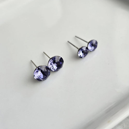 Wixies 8mm or 6mm Indigo Violet Studs with deep blue-purple faceted stones in stainless steel on a neutral surface
