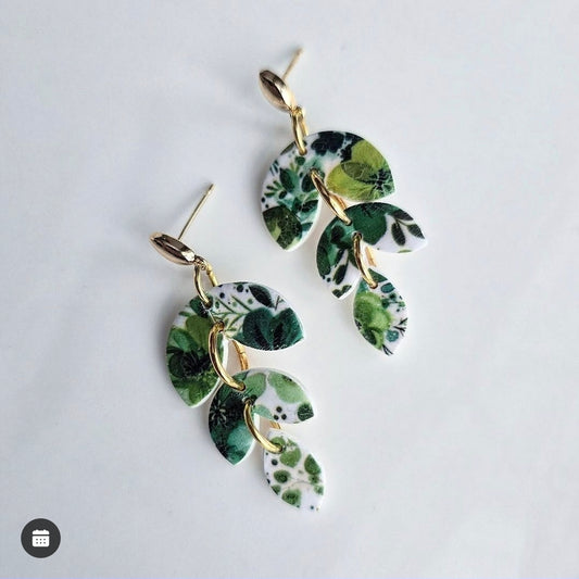 Wixies Green Floral Dangles featuring cascading leaf shapes with green botanical print and gold links on white background