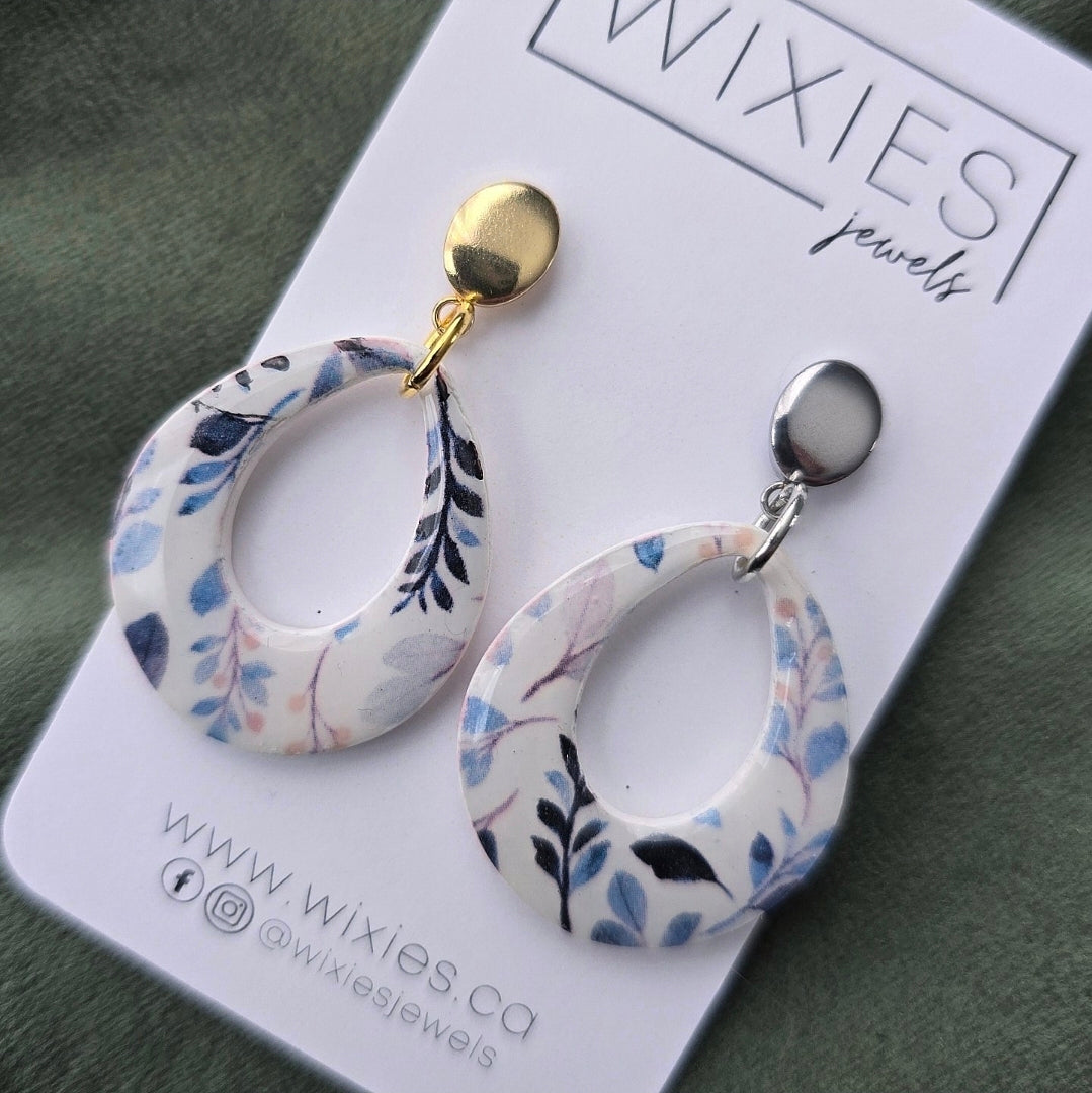 Big Blue Drops featuring asymmetrical floral resin open hoop earrings with mixed metal posts by Wixies Handmade and Picked in Nova Scotia