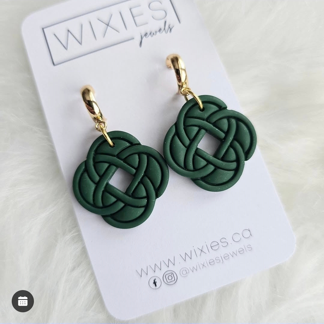 Celtic Knot Dangles by wixies featuring dark green intricate knot charms with gold hoops on white branded card