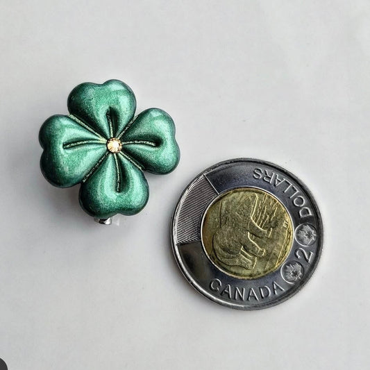 Wixies Shamrock Brooch with green metallic finish and gold center displayed next to Canadian two dollar coin for scale
