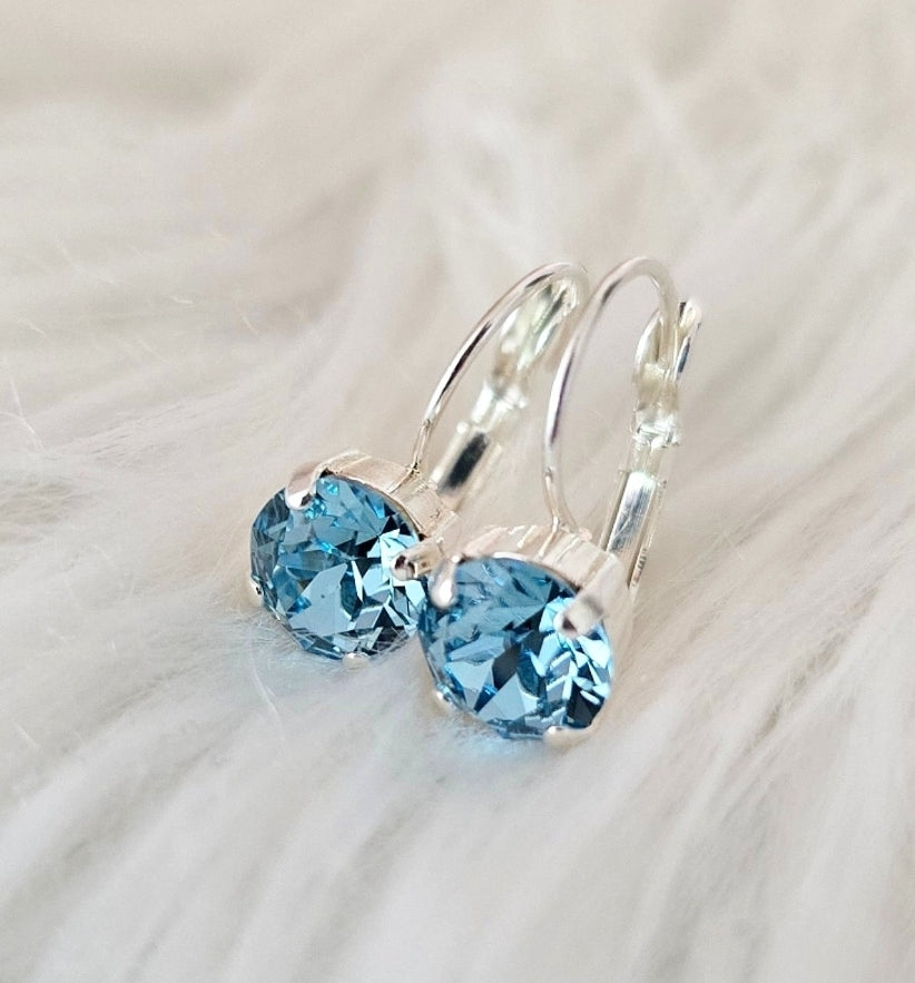 Aquamarine 8mm Lever Back earrings with sparkling blue gems and silver tone setting by Wixies on soft white background