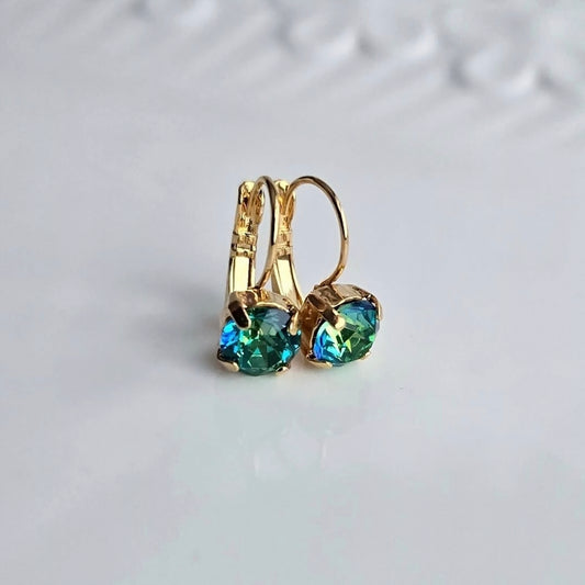 Wixies *Limited Edition* Green Colour Shift Lever Back earrings with vibrant shifting green-blue stones in gold settings on white surface